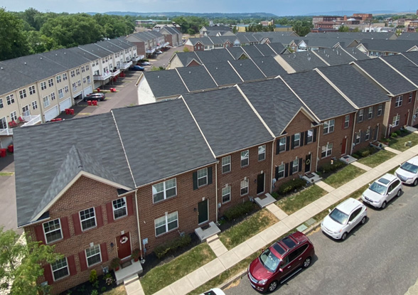 Aerial view of a row of townhouses with parked cars.